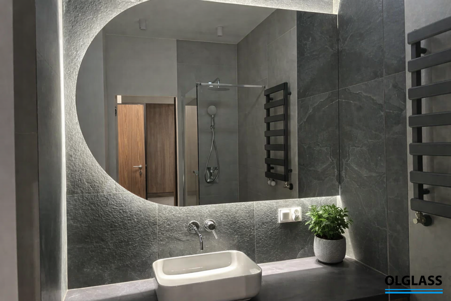 Podświetlane lustro łazienkowe nad umywalką w nowoczesnym wnętrzu z ciemnymi płytkami, Gdańsk, Sopot, Gdynia, Trójmiasto.